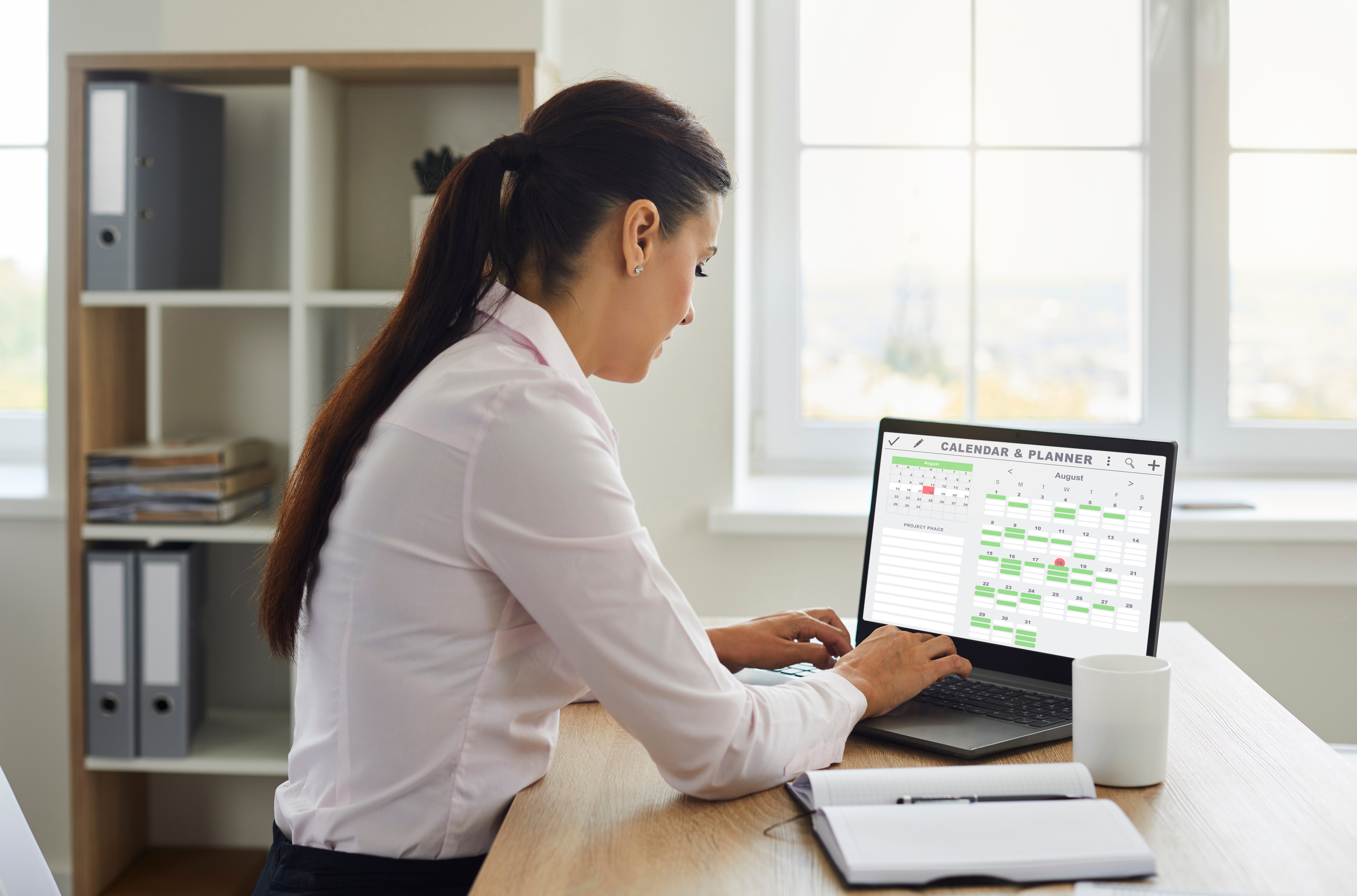 Woman organizing her work schedule using Calendar and Planner on laptop computer