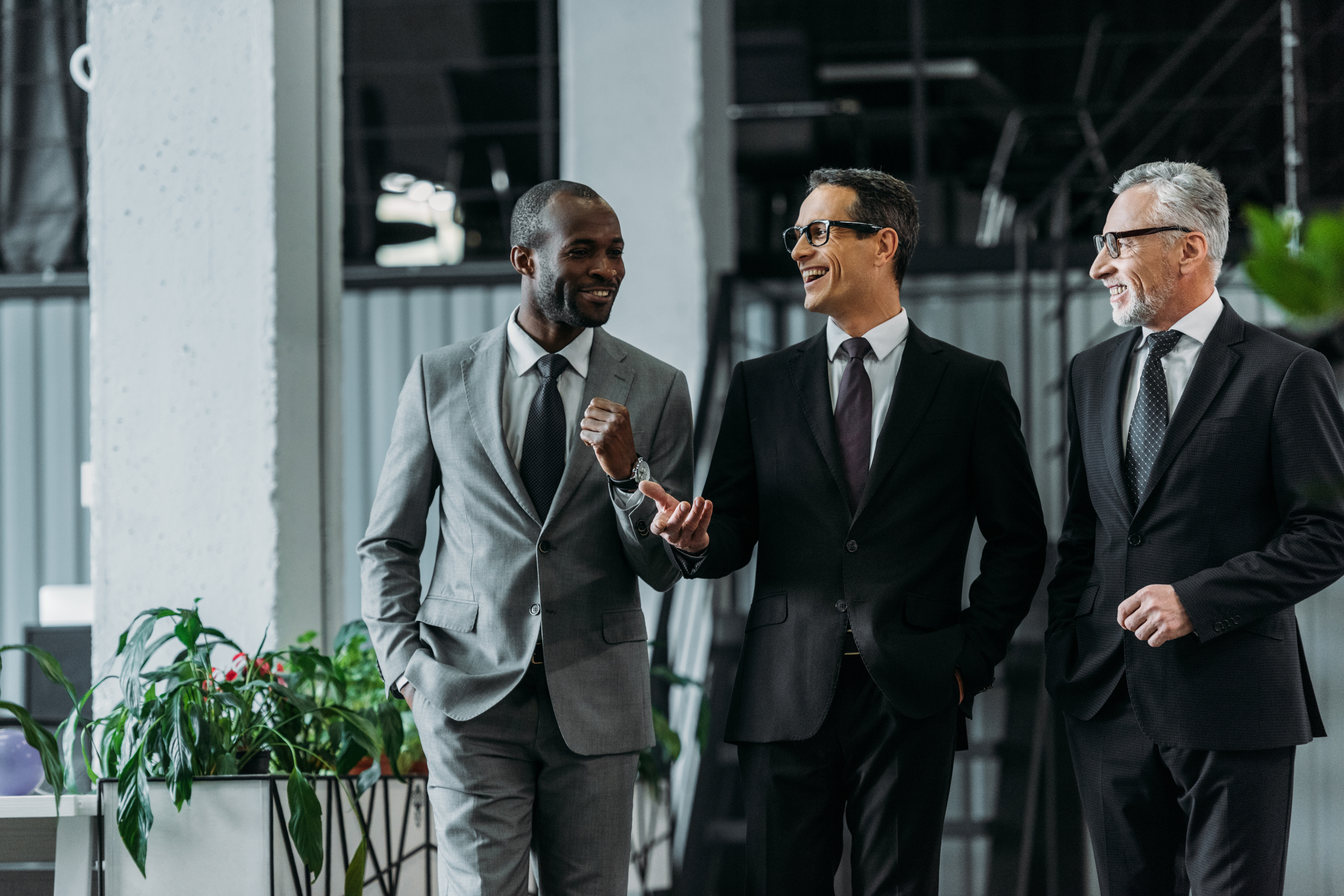 smiling multiracial businessmen having conversation while walkin